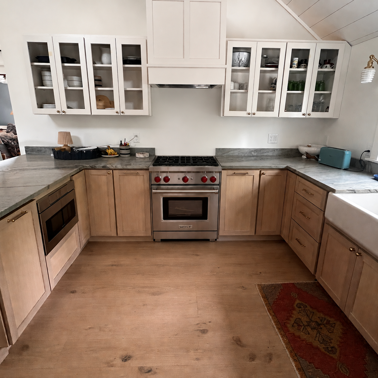 Kitchen with Wolf range, glass-front cabinets, and quartzite counters